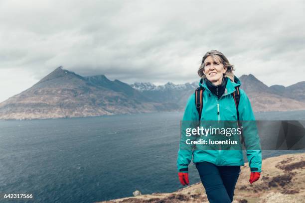 vrouwelijke wandelaar 50-59years, lopen op coastal trail in skye, schotland - cuillins stockfoto's en -beelden