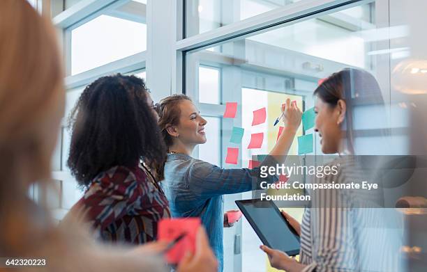 businesswomen discussing project in office - cef do not delete stock pictures, royalty-free photos & images