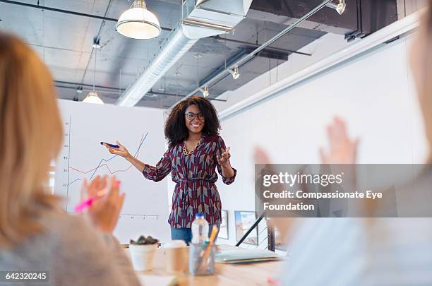 businesswoman leading meeting - business woman pointing stock-fotos und bilder