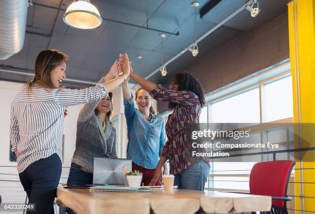 businesswomen cheering in office - montreal black and white photos et images de collection