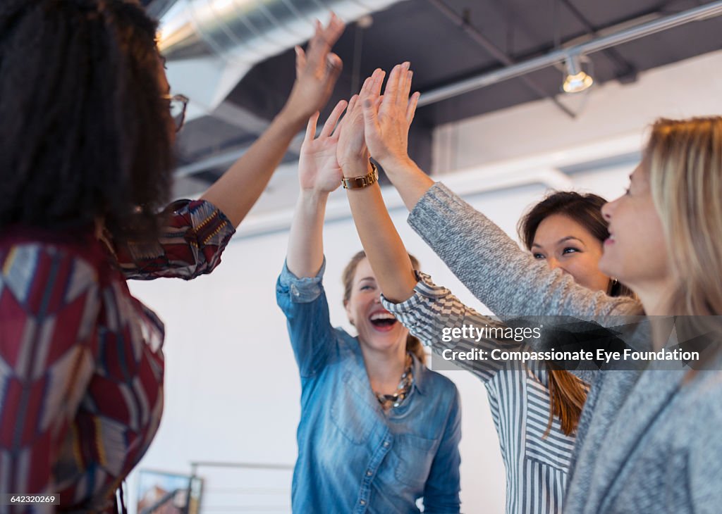 Businesswomen cheering in office