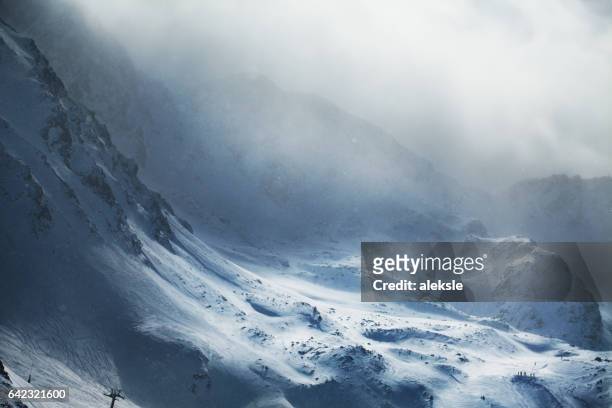 wunderschönen winterbergen auf stürmisches wetter - schneesturm stock-fotos und bilder