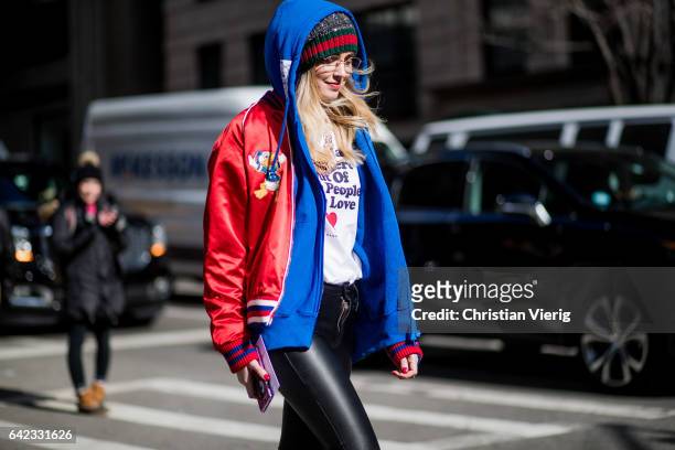 Chiara Ferragni wearing wearing a Gucci beanie, a white tshirt, red college jacket, black cropped leather pants, glasses outside Marc Jacobs on...
