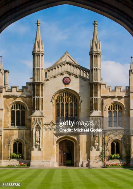 symmetrical view of lawn and cambridge university building framed by silhouetted archway - pináculo campanário imagens e fotografias de stock