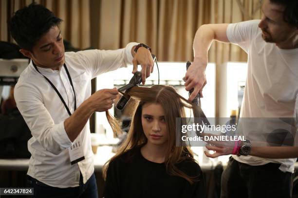 Models are prepared backstage before a catwalk show by DAKS on the first day of the Autumn/Winter 2017 London Fashion Week in London on 17 February...