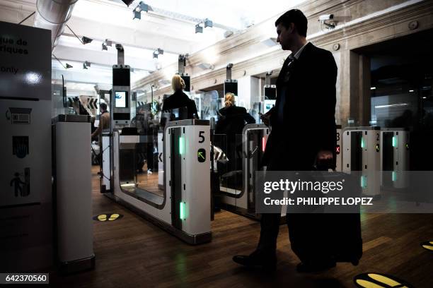 Passengers use their biometric passport at an automated ePassport gate equiped with a facial recognition system at the British border of the Eurostar...