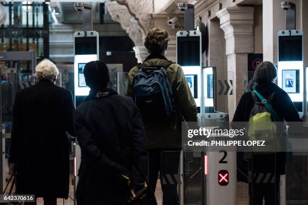 Passengers use their biometric passport at an automated ePassport gate equiped with a facial recognition system at the British border of the Eurostar...