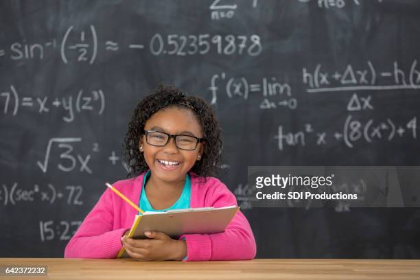 happy elementary student with glasses in the classroom - mathematical symbol stock pictures, royalty-free photos & images