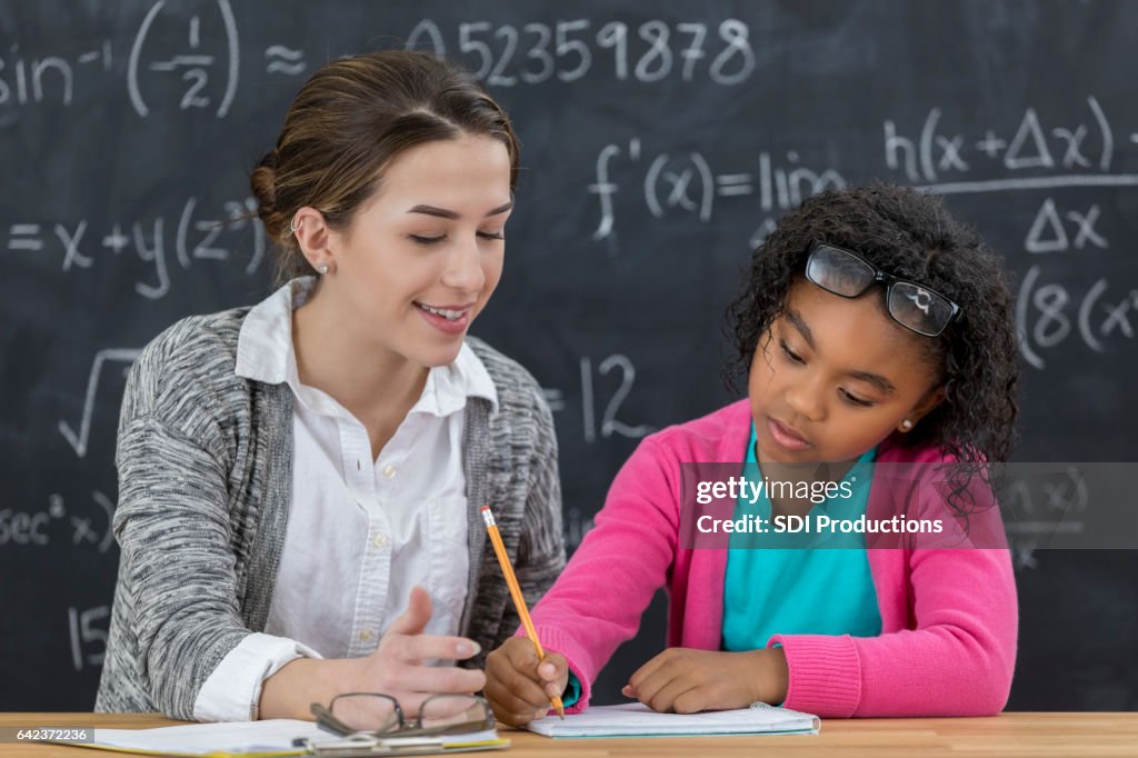 L'insegnante di matematica aiuta la studentessa elementare con l'incarico di matematica