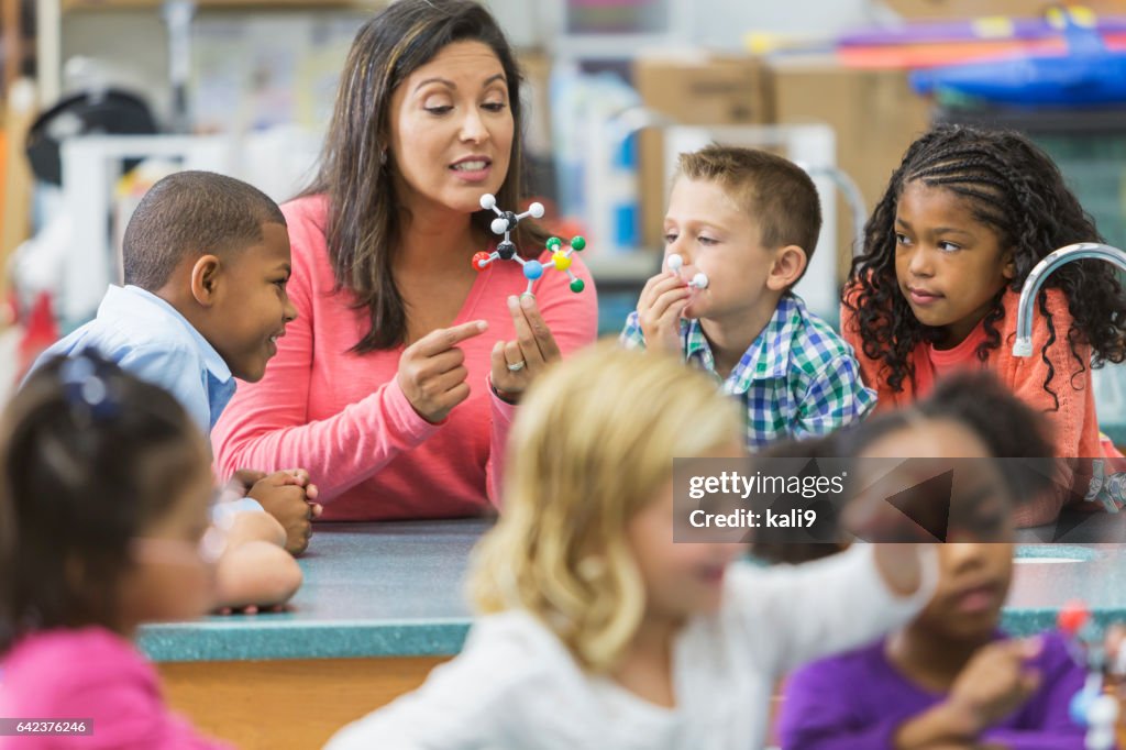 Multiracial teacher and children in science lab