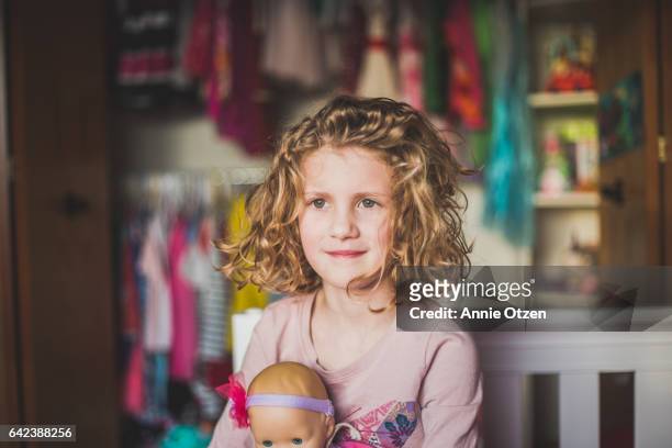 little girl sitting in bedroom - annie otzen stock pictures, royalty-free photos & images