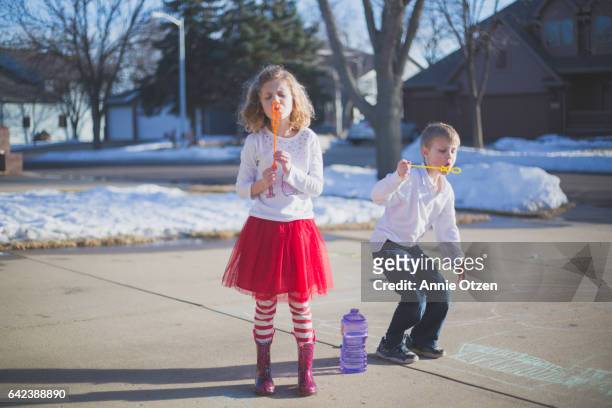 children blowing bubbles - annie otzen stock pictures, royalty-free photos & images