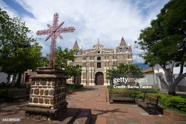 iron cross in front of church - antioquia stock pictures, royalty-free photos & images