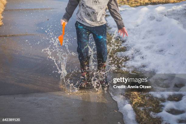 boy splashing in puddle - annie sprinkle stock pictures, royalty-free photos & images