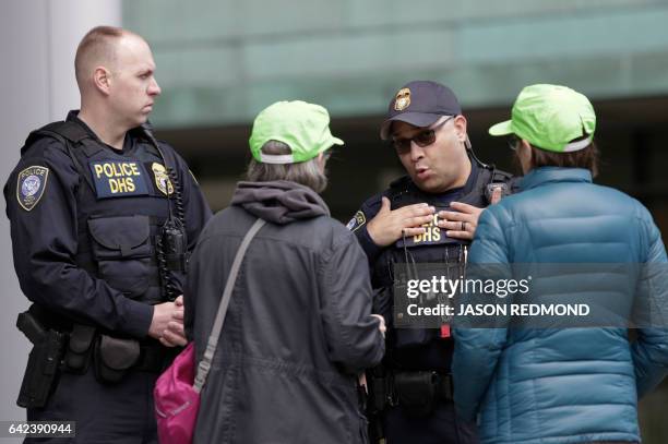 Legal observers from the National Lawyers Guild speak to Department of Homeland Security officers outside US District Court during a hearing for...