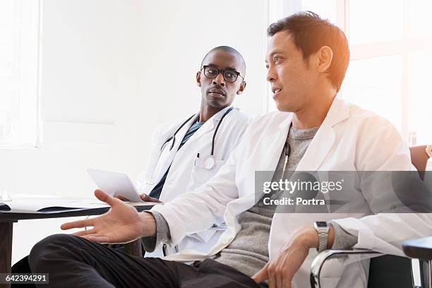 professionals discussing in doctor's office - two doctors talking stockfoto's en -beelden