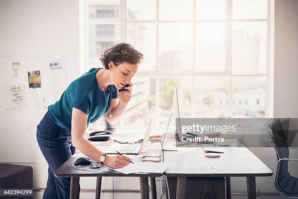 businesswoman on phone talking to client - ミディアムヘア ストックフォトと画像