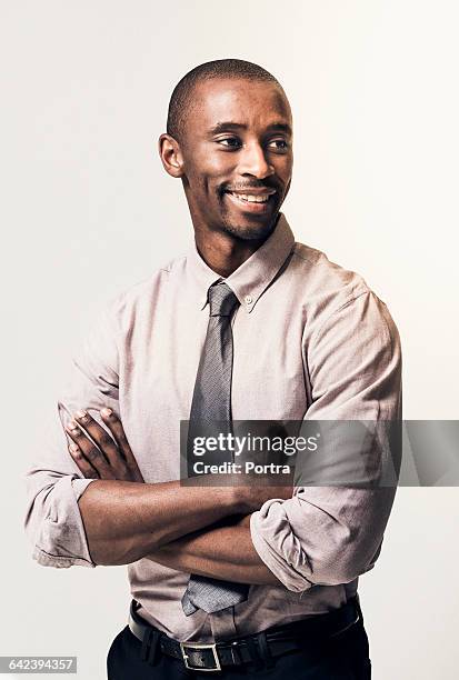 thoughtful smiling businessman with arms crossed - portrait white background looking away stockfoto's en -beelden