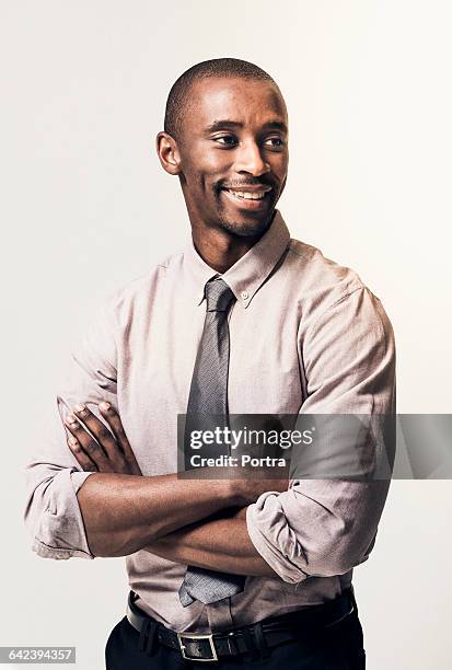 thoughtful smiling businessman with arms crossed - african ethnicity business man stock pictures, royalty-free photos & images