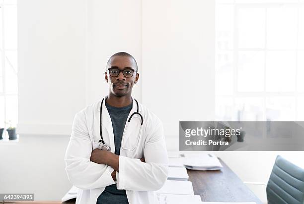 portrait of smiling male doctor standing in office - parte di una serie foto e immagini stock