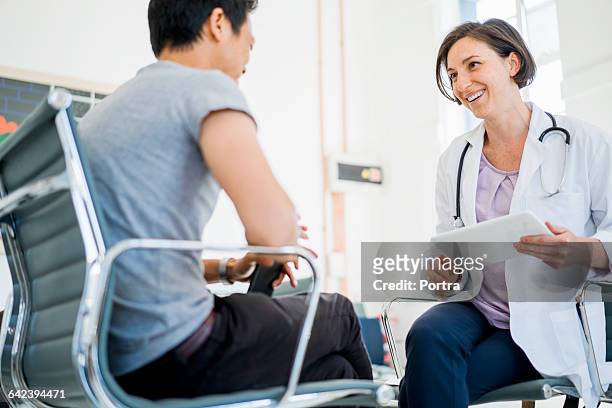 happy female doctor with patient in hospital - health care professional with patient stockfoto's en -beelden