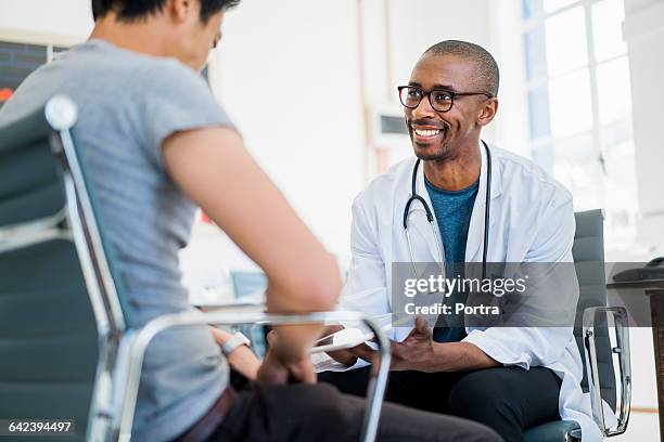 doctor showing results to patient in hospital - adult patient with doctor and stethoscope foto e immagini stock