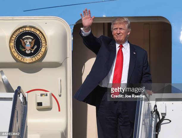 President Donald Trump waves as he arrives on Air Force One at the Palm Beach International Airport to spend part of the weekend at Mar-a-Lago resort...