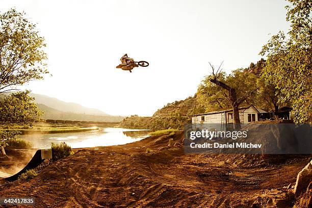 freestyle motocross rider jumping over huge jump. - motorcycle stunt stock pictures, royalty-free photos & images