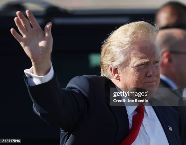 President Donald Trump waves to supporters after arriving on Air Force One at the Palm Beach International Airport to spend part of the weekend at...
