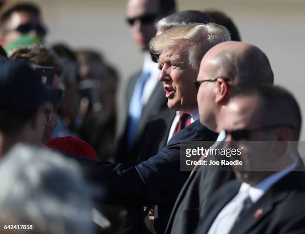 President Donald Trump shakes hands with supporters after arriving on Air Force One at the Palm Beach International Airport to spend part of the...