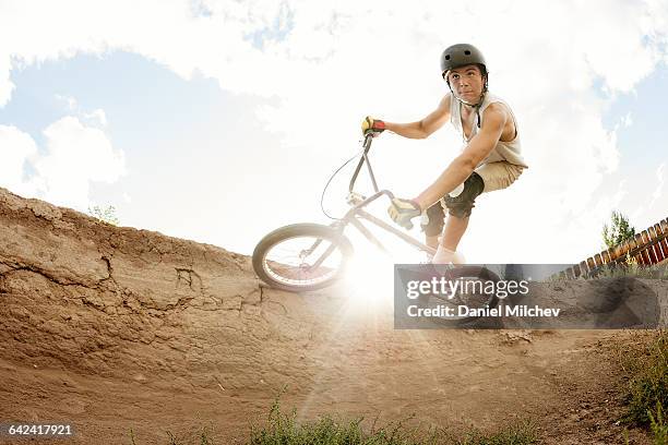 kid riding bmx bike with sun flaring. - teenager cycling helmet stock pictures, royalty-free photos & images