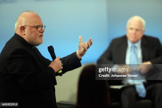 Munich catholic archbishop Reinhard Marx speaks to U.S. Senator John McCain participates in a panel talk at the 2017 Munich Security Conference on...