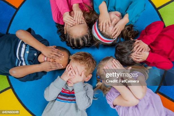 lying in a circle - kid hide and seek stock pictures, royalty-free photos & images