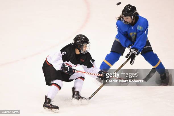 Sena Suzuki of Japan and Aida Olzhabayeva battle for the puck during the Women's Ice Hockey match between Kazakhstan and Japan on the day one of the...