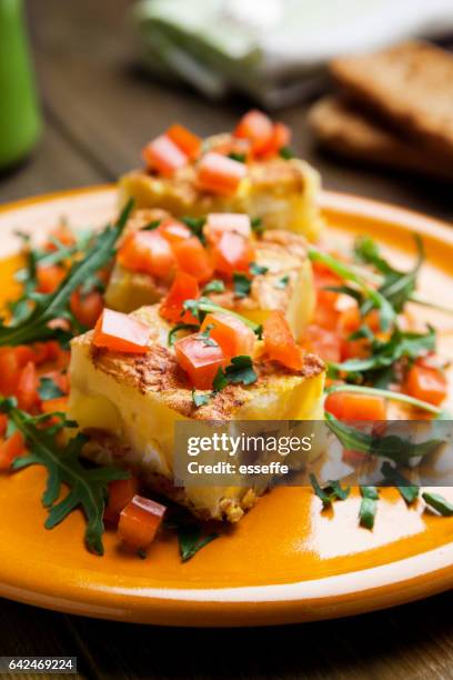 tortilla de patata preparada con trozos de rúcula y tomates - tortilla de patata fotografías e imágenes de stock