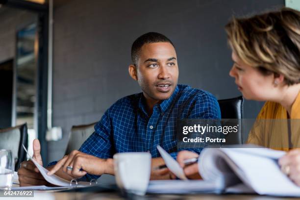 businessman discussing with colleague in office - preppy stock pictures, royalty-free photos & images