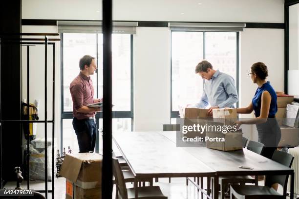geschäftsleute packen kisten am tisch im büro - moving office stock-fotos und bilder