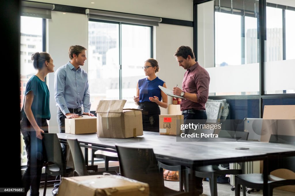 Businesswoman discussing with coworkers at table