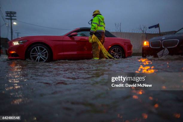 Firefighter checks on stalled cars in a flooded street as a powerful storm moves across Southern California on February 17, 2017 in Sun Valley,...