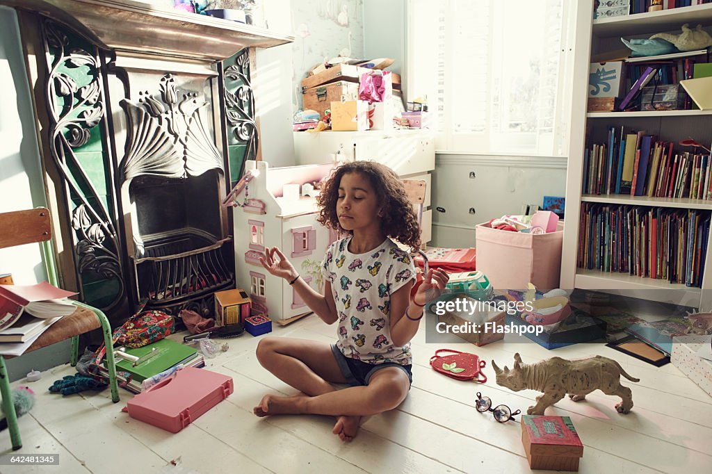 Girl meditating in bedroom