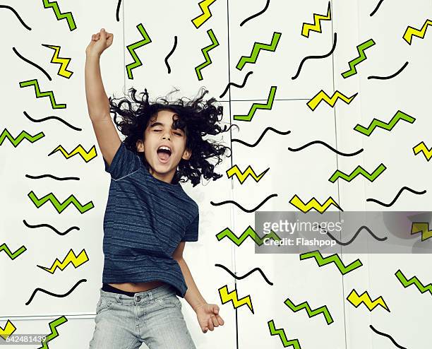 boy jumping in the air with graphic symbols - multi coloured trousers stockfoto's en -beelden