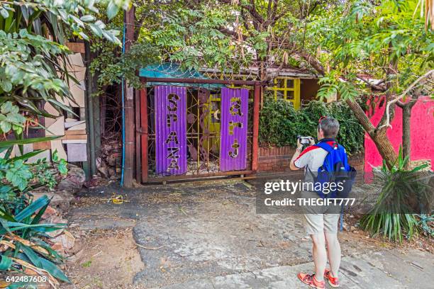 tourist photographing entrance to spaza arts shop - spaza shop stock pictures, royalty-free photos & images