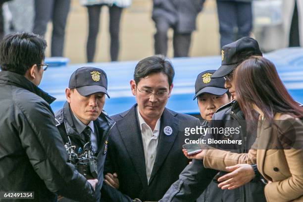 Jay Y. Lee, co-vice chairman of Samsung Electronics Co., center, is escorted by police officers as he arrives at the special prosecutors' office in...