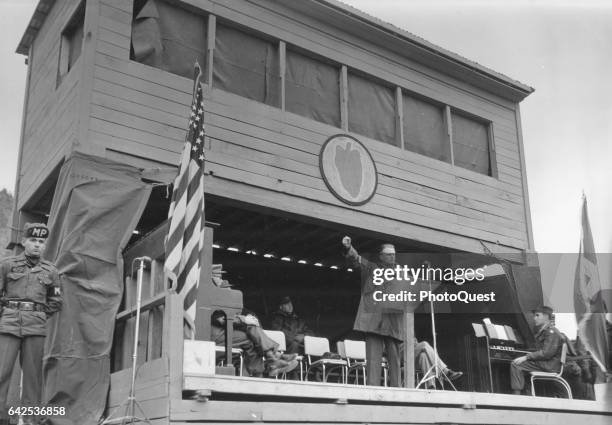 Evangelist Billy Graham raises his fist as he speaks to members of the 24th Infantry Division, Korea, February 1956.