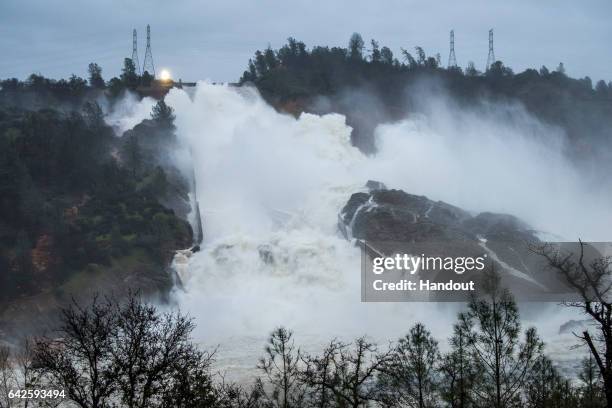 In this handout provided by the California Department of Water Resources , Water continues to move down the damaged spillway at Oroville Dam with an...