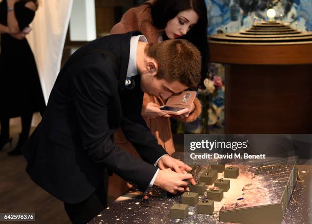 Guests tries on jewellery during the Astley Clarke AW17 Presentation during London Fashion Week at Savoy Place on February 18, 2017 in London,...