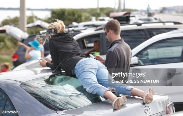 Spectators gather along a shore of Port Canaveral, Florida to watch the launch of a Falcon 9 rocket of SpaceX, ferrying cargo to the International...