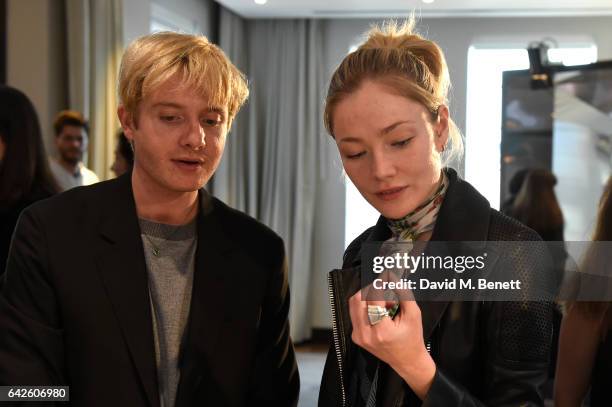 Creative director Dominic Jones shows the jewellery to model and actress Clara Paget during the Astley Clarke AW17 Presentation during London Fashion...