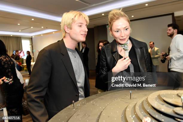 Creative director Dominic Jones shows the jewellery to model and actress Clara Paget during the Astley Clarke AW17 Presentation during London Fashion...