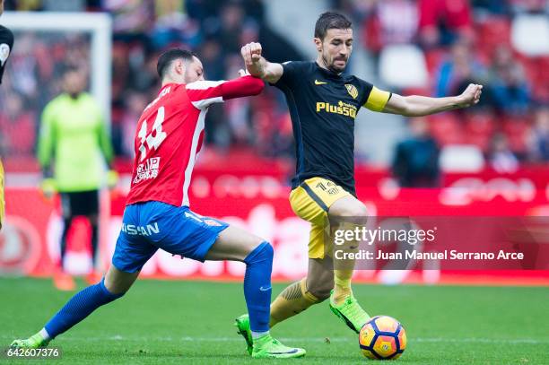 Gabi Fernandez of Atletico Madrid duels for the ball with Jorge Franco 'Burgui' of Real Sporting de Gijon during the La Liga match between Real...